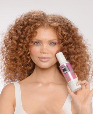 a woman holding a bottle of hair
