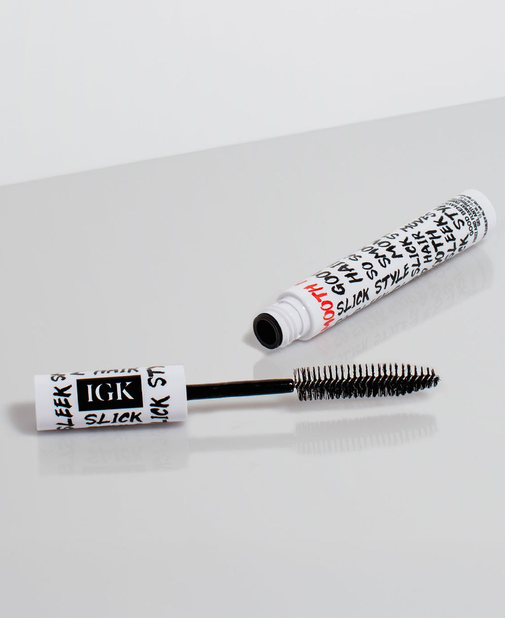 XL Taming Wand with black brush and white cylindrical container on a light gray background