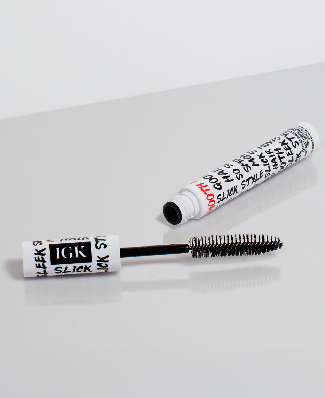 XL Taming Wand with black brush and white cylindrical container on a light gray background